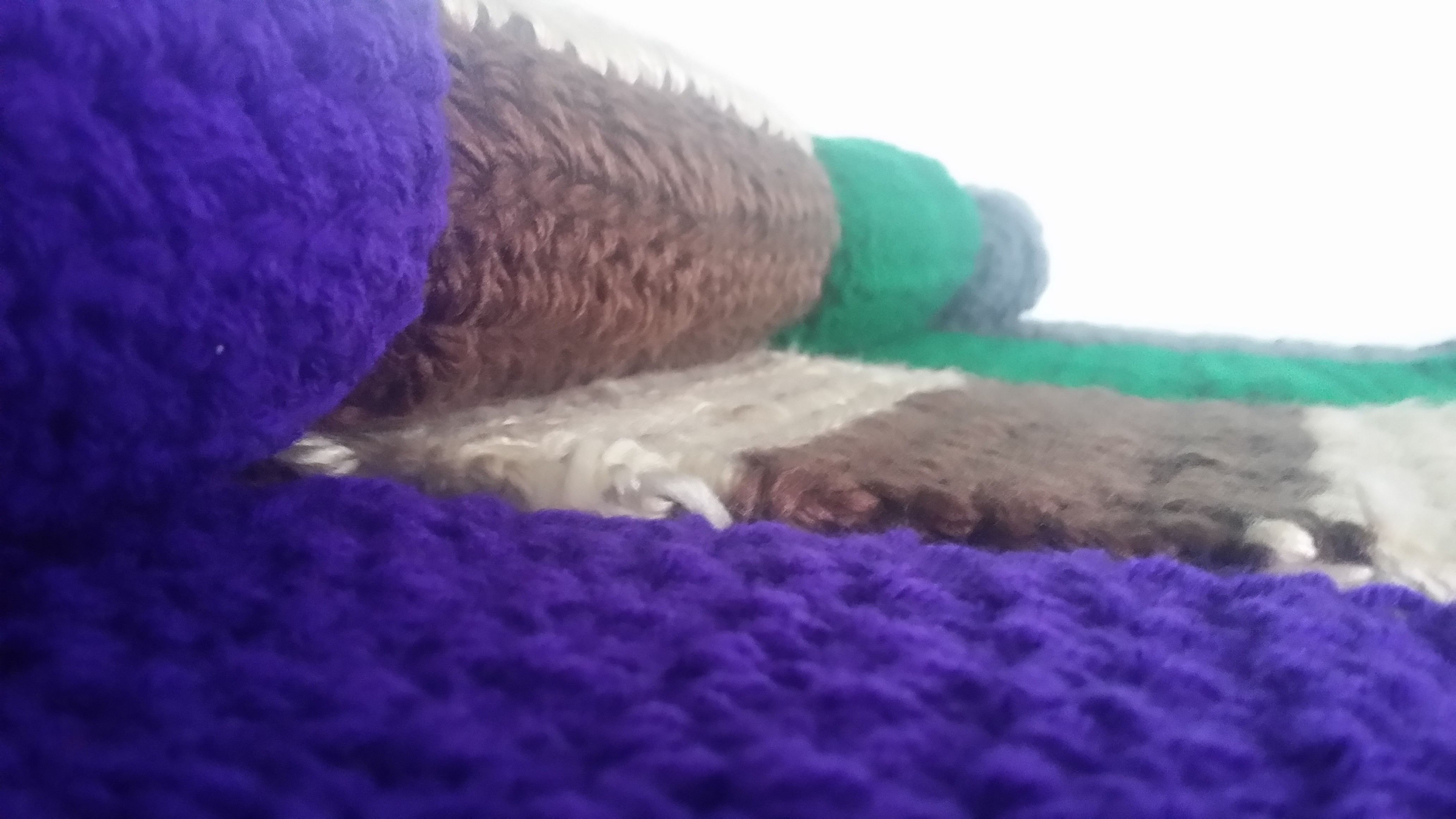 four condense scarves: gray, green, purple, tan and brown.