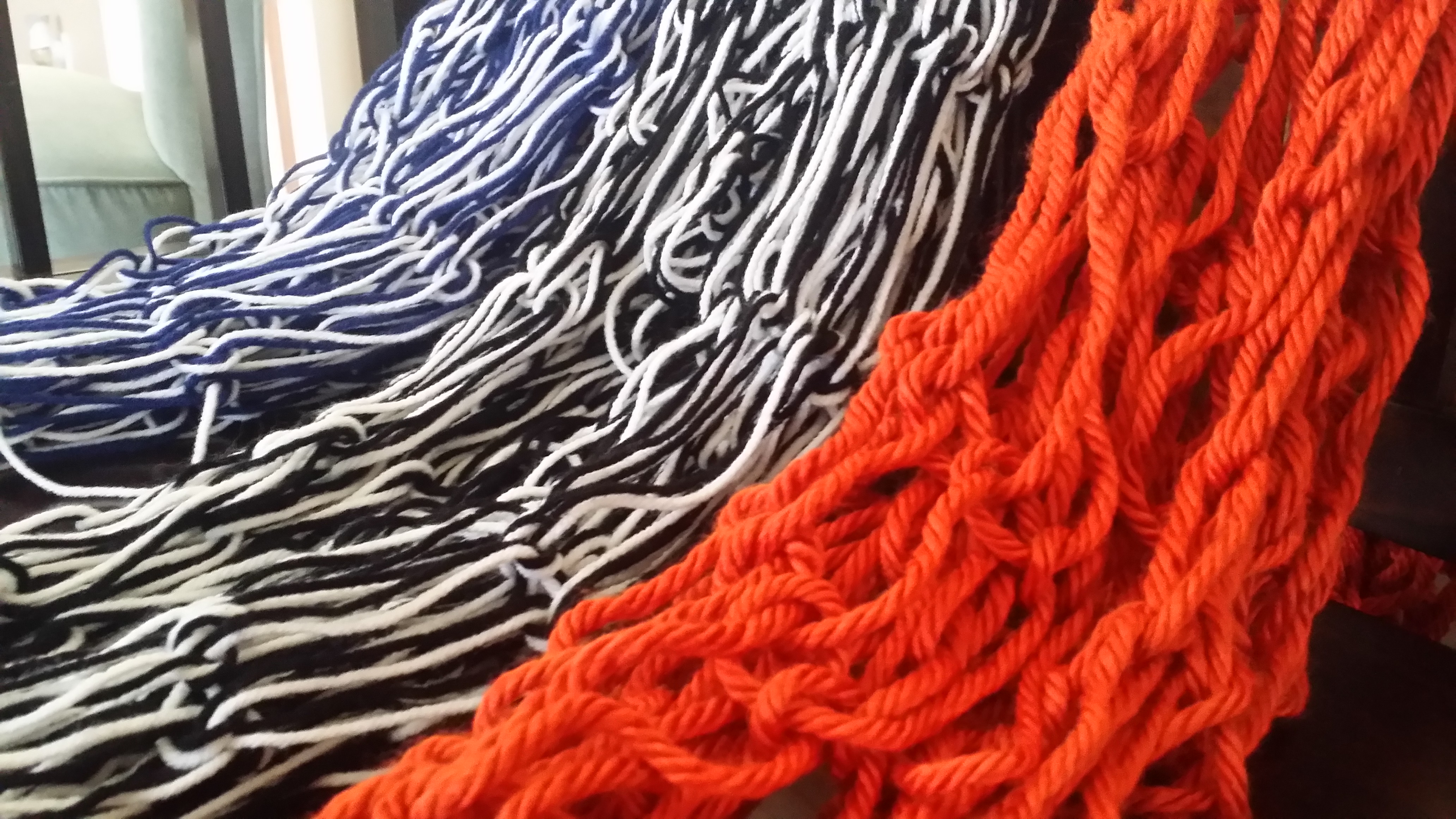 three loose scarves: orange, black and blue, black and white.